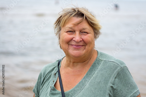 Mature plump woman resting on the beach of the sea