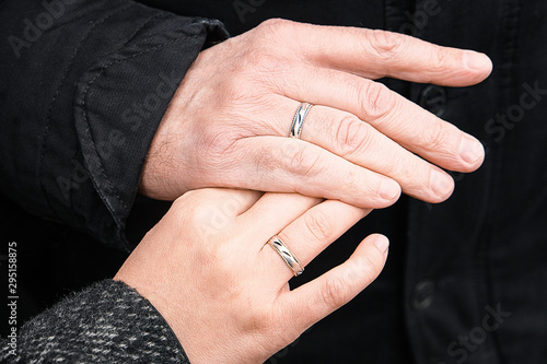 Wedding rings on his hands. An elderly couple got married. Happy family. Family outdoors.