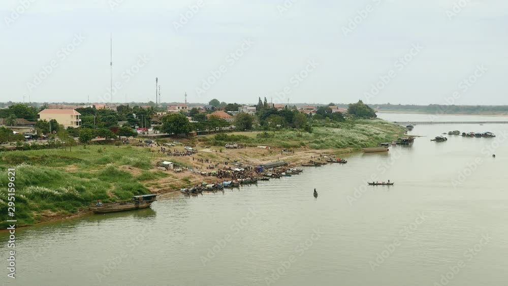 distance view on a morning fish market located on the riverbank next to town; Fishermen coming by boat to sell freshly caught fish ( morning time) distance view on a morning fish market located on the riverbank next to town; Fishermen coming by boat to sell freshly caught fish ( morning time)
