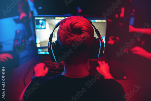 Fototapeta Professional gamer playing online games tournaments pc computer with headphones,