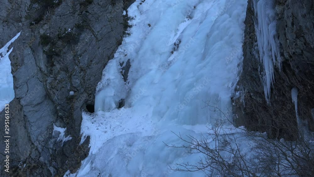 Panning shot of two of the many frozen waterfall cascades in the Dabaklamm, a very steep and narrow gorge in the Hohe Tauern nature reserve mountain region, Tirol Austria making the way unpassable in Panning shot of two of the many frozen waterfall cascades in the Dabaklamm, a very steep and narrow gorge in the Hohe Tauern nature reserve mountain region, Tirol Austria making the way unpassable in