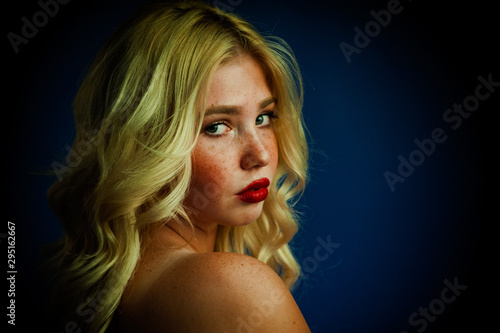 Portrait of blond girl young woman with freckles and blue eyes