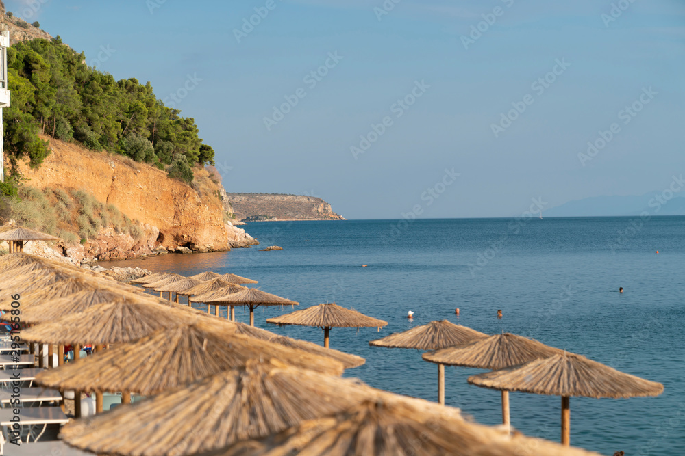 Sun shade umbrellas lined up along waters edge in summer for beach goers and holiday makers to relax under.