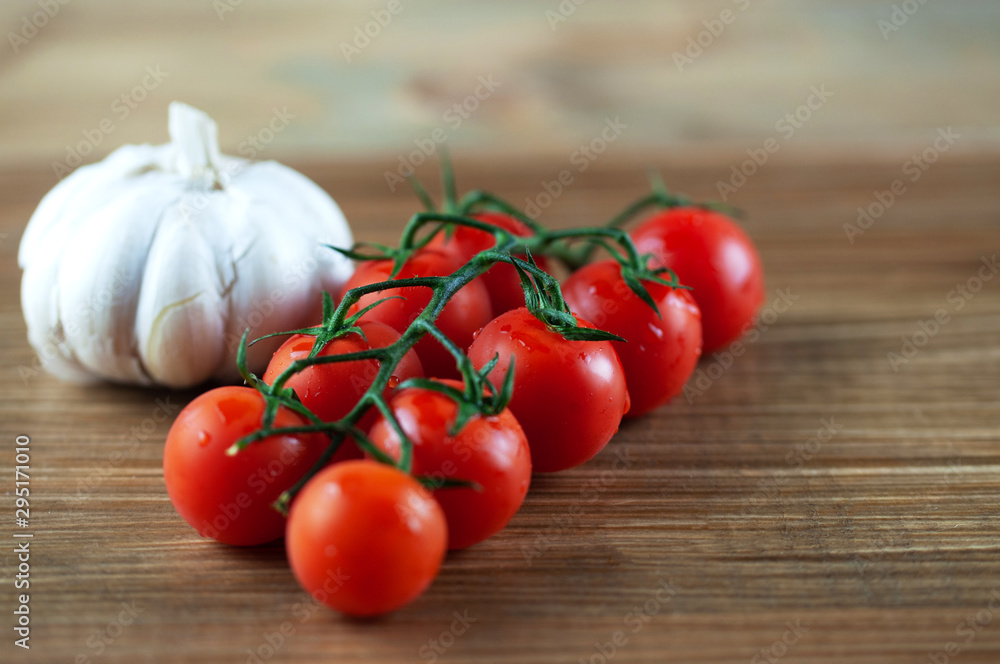 cherry tomatoes with garlic on wooden background cherry tomatoes with garlic on wooden background