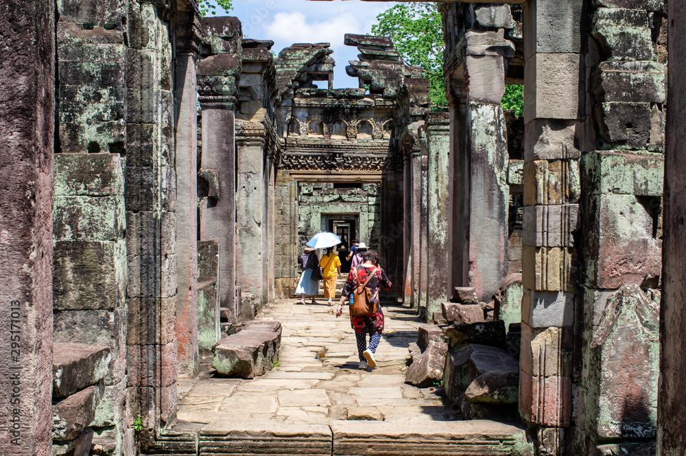 Siem Reap / Cambodia - May 27 / 2019 : tourists walking between the arches of the preah khan temple at angkor wat temple complex