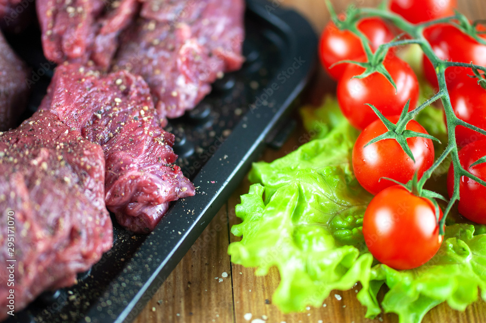 fresh grilled meat with cherry tomatoes, lettuce, garlic and seasonings