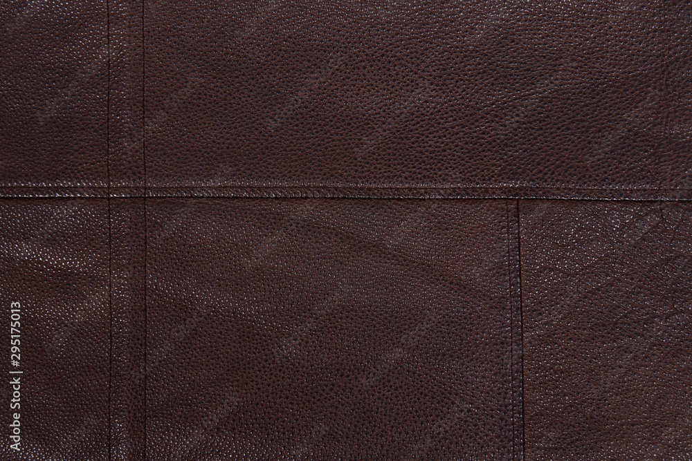 Dark brown stitched leather background. Asymmetric seams. Rough surface with free space. Expensive material sample. Handwork. Seat upholstery or leather jacket. Dark brown stitched leather background. Asymmetric seams. Rough surface with free space. Expensive material sample. Handwork. Seat upholstery or leather jacket.