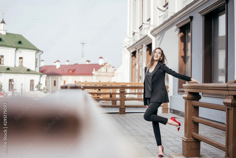 Business girl in a black suit against the background of the city Business girl in a black suit against the background of the city