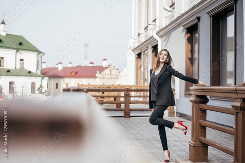 Business girl in a black suit against the background of the city © majorik0207