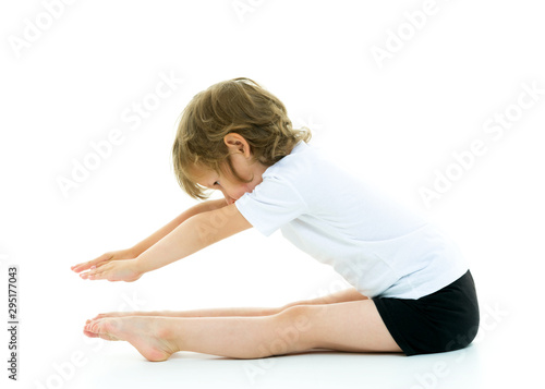 Charming little girl doing gymnastic exercises in the studio on