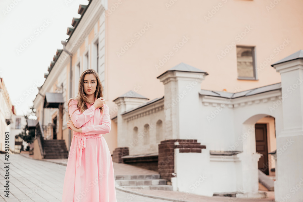 A young, beautiful girl in a pink dress walks through the beautiful streets in the city. Very beautiful portraits of a girl in the city. A young, beautiful girl in a pink dress walks through the beautiful streets in the city. Very beautiful portraits of a girl in the city.