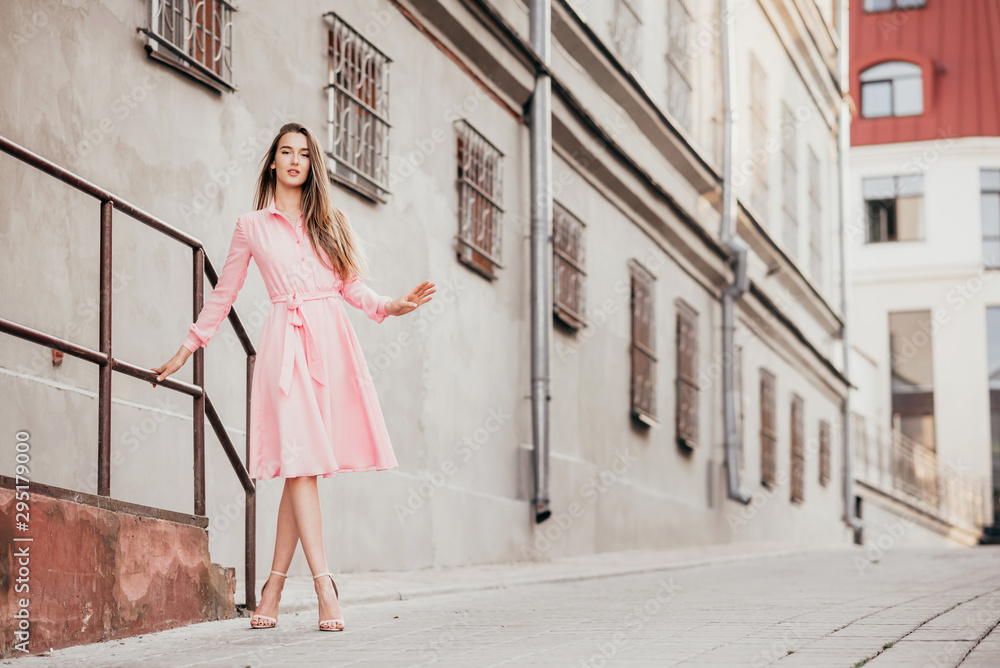 A young, beautiful girl in a pink dress walks through the beautiful streets in the city. Very beautiful portraits of a girl in the city. A young, beautiful girl in a pink dress walks through the beautiful streets in the city. Very beautiful portraits of a girl in the city.