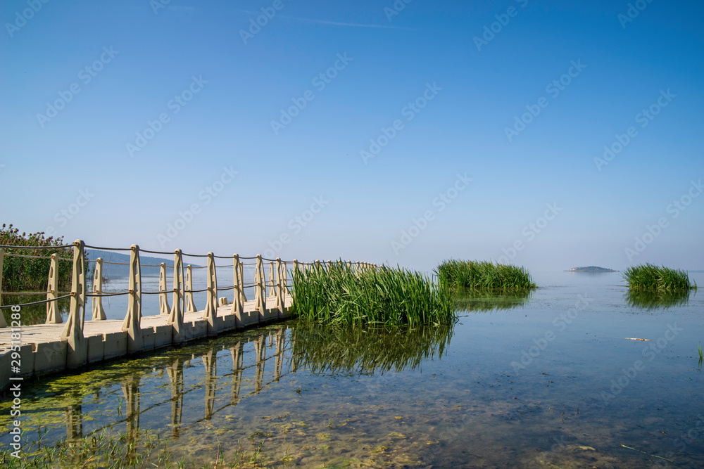 a beautiful lake with a platform under a shiny blue sky