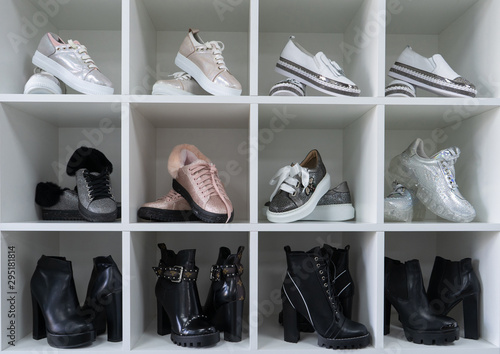 Fashion shoe of famouse brands is on the shelf. Сloset in which everything put in order. All shoes are folded neatly. Everything is in its place. Harmony. Showroom. 