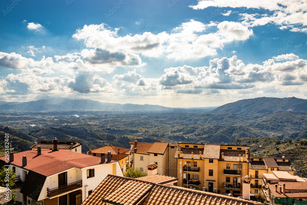 Bellegra, Rome, Lazio, Italy - The panorama seen from Bellegra, with the Prenestini mountains and the Sacco Valley. The cloudy blue sky at sunset. The roofs of houses. Mountains and sunbeams.