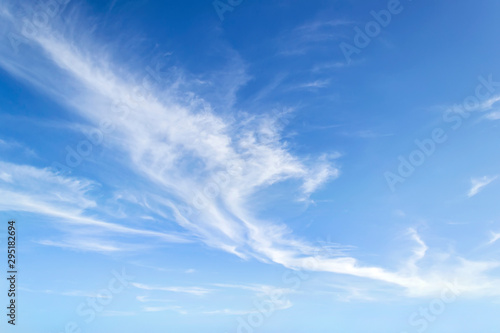 Translucent airy cirrus clouds high in a blue sky. Cloud species and varieties. Atmospheric phenomena. Skyscape on a sunny day. photo