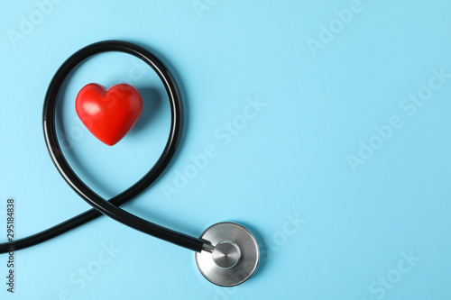 Stethoscope and heart on blue background, top view photo