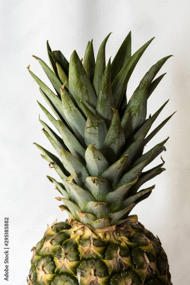 Fototapeta premium Unpeeled part of a pineapple with stalk