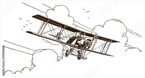 Antique biplane flying out of the clouds