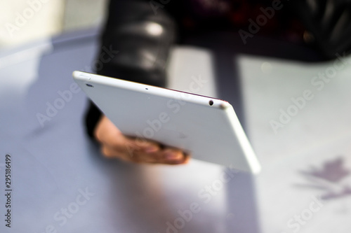 Close up on a woman using digital tablet on marble table, she uses business applications and technology app