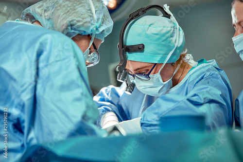 Fotografia Group of surgeons looking at patient on operation table during their work