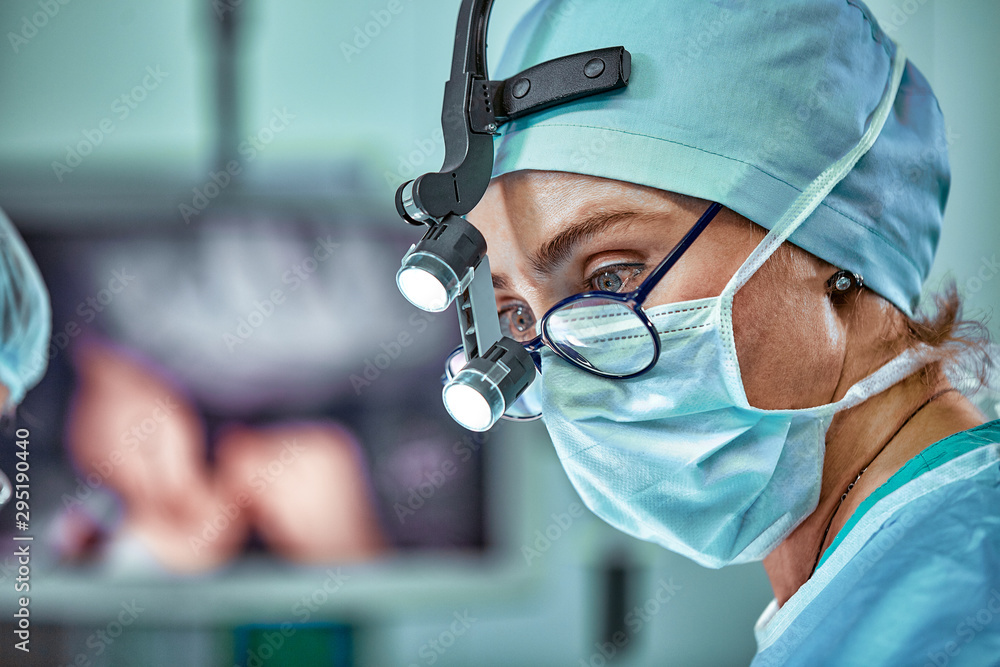 Female surgeon in operation room with reflection in glasses - obrazy, fototapety, plakaty 