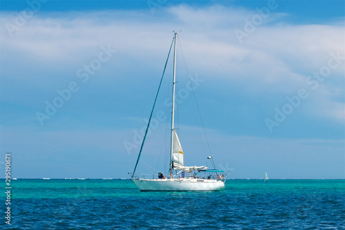 Sailboat at anchor in turquoise and blue water at San Pedro Belize