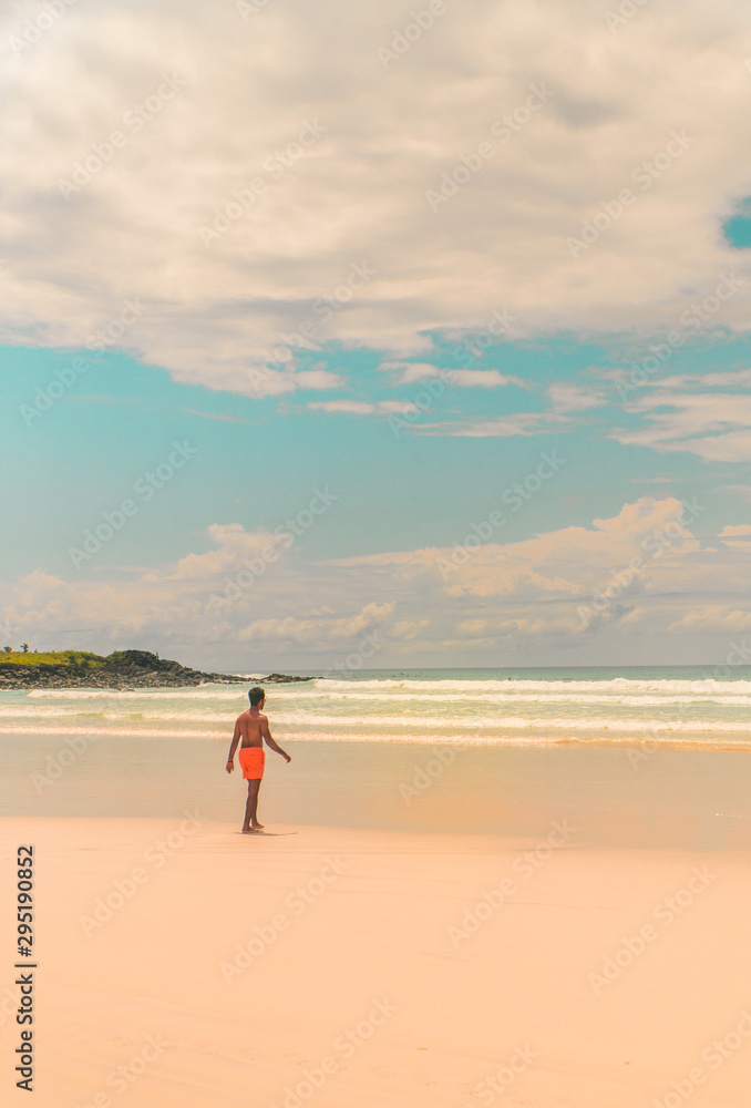 Man tourist on Galapagos beach. Tourist man walking along Tropical beach with turquoise ocean waves and white sand. Sand bay view. Holiday, vacation, paradise, summer vibes. Shot in Isabela, San Crist Man tourist on Galapagos beach. Tourist man walking along Tropical beach with turquoise ocean waves and white sand. Sand bay view. Holiday, vacation, paradise, summer vibes. Shot in Isabela, San Crist