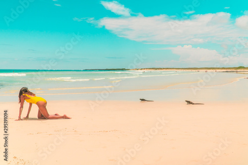 Woman  Iguana playing on beach Galapagos. Tourist on Tropical beach with turquoise ocean waves and white sand. Sand bay view. Holiday  vacation  paradise  summer vibes. Isabela  San Cristobal