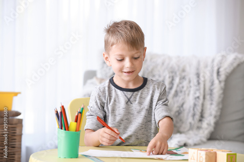 Cute little boy drawing picture at home