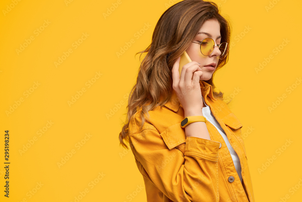 Attentive woman in bright clothes talking on phone Attentive woman in bright clothes talking on phone