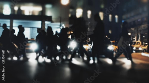 Anonymous Crowd Of Pedestrians Cross A Busy City Intersection at Night