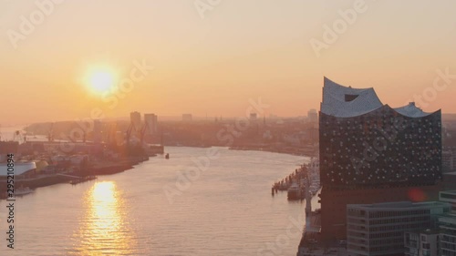 4K Aerial Elbe river in Hamburg during sunrise, Elbphilharmonie concert hall modern building and sailing ships photo