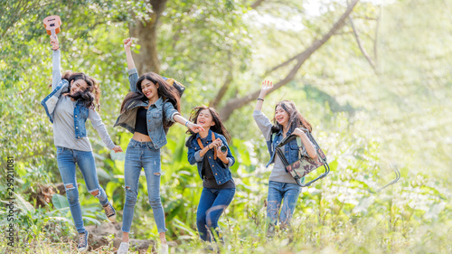 Group of  Asian female  having fun hiking outdoor in deep forest  holiday.