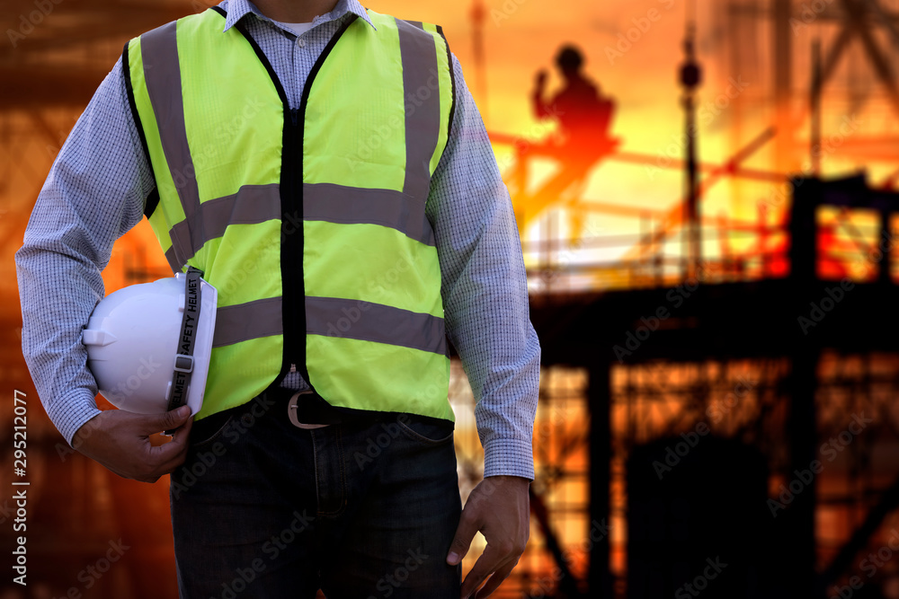 Engineer or Safety officer holding hard hat with construction site. Engineer or Safety officer holding hard hat with construction site.