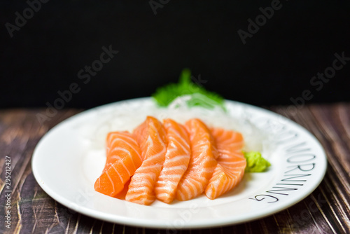 Fresh salmon, sushi with chopsticks on a wooden table
