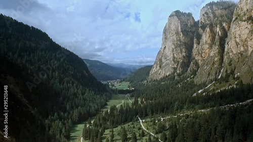 Grand vista of beautiful valley in the Alps. Rock towers, green meadows, dark forest and dramatic clouds in the sky. photo