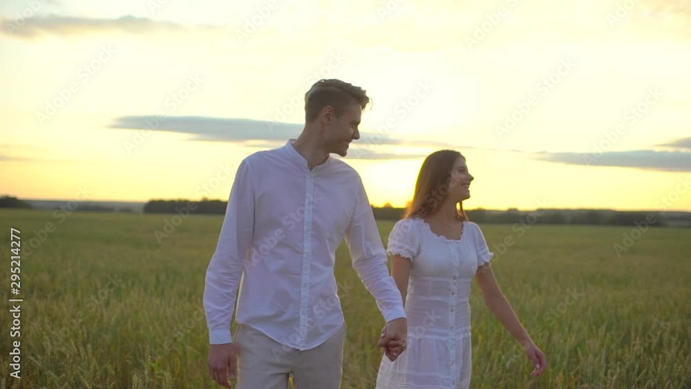 happy couple outdoors having fun, walking on wheat field at sunset nature. romantic happy family in Love. Young man woman holding hands. Freedom Happiness Travel Summertime, Sun lens flare slow motion happy couple outdoors having fun, walking on wheat field at sunset nature. romantic happy family in Love. Young man woman holding hands. Freedom Happiness Travel Summertime, Sun lens flare slow motion