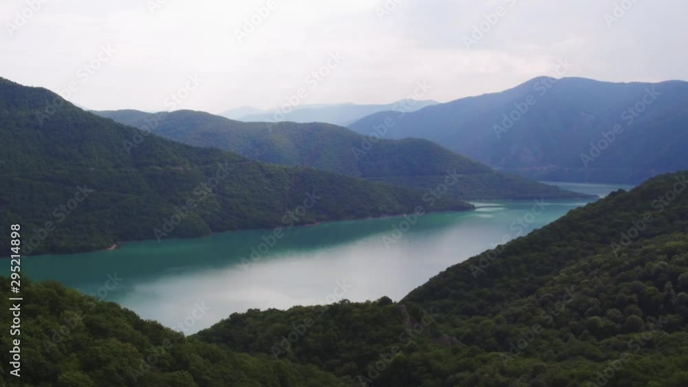 Emerald lake in Caucasian Mountains, forest hilly at summer sunny day - Aerial drone view Emerald lake in Caucasian Mountains, forest hilly at summer sunny day - Aerial drone view