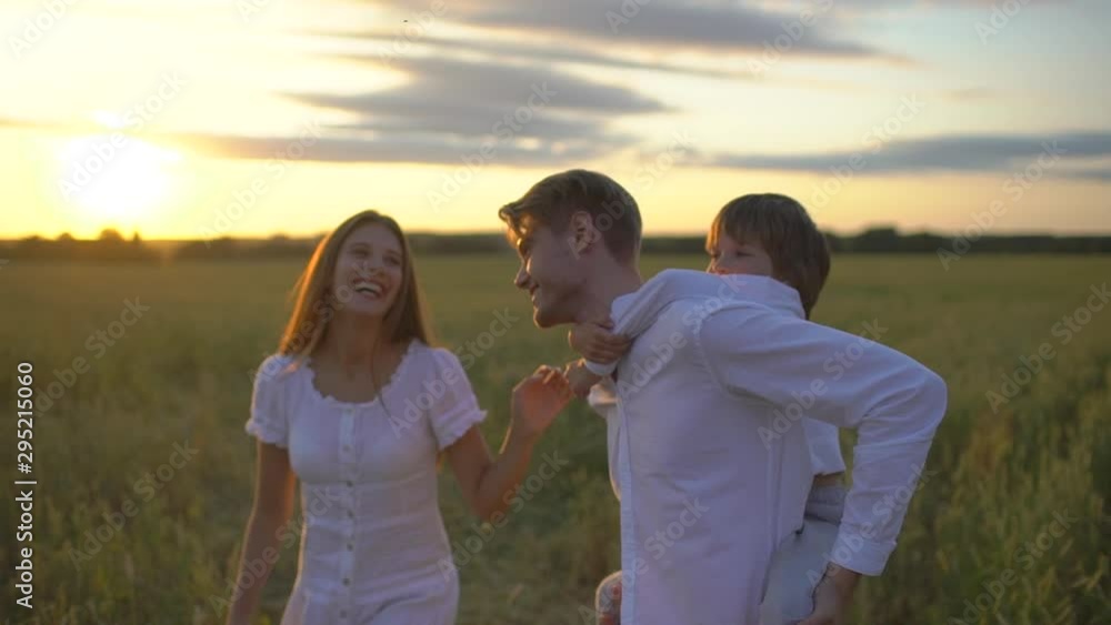 happy family outdoors walking on wheat field with little boy. Mother, father, son child having fun on summer day enjoying nature together, health love travel summertime happy holiday happiness sunset happy family outdoors walking on wheat field with little boy. Mother, father, son child having fun on summer day enjoying nature together, health love travel summertime happy holiday happiness sunset