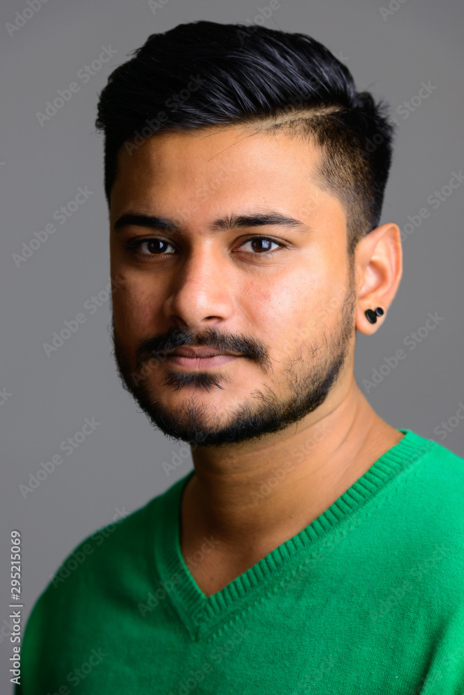 Fototapeta premium Face of young handsome Indian man looking at camera