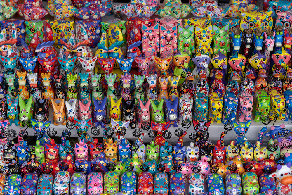 Sale of souvenirs - funny handmade wooden animals in street market. Bright colorful children toys and decoration for interior. Ubud, Bali island, Indonesia. Closeup