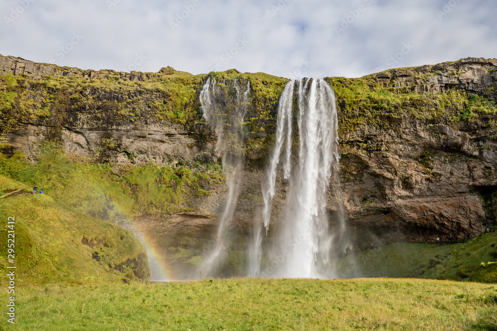 Seljalandsfoss waterfall drops from cliffs that allow people to walk behind the falls in Southern Iceland Seljalandsfoss waterfall drops from cliffs that allow people to walk behind the falls in Southern Iceland