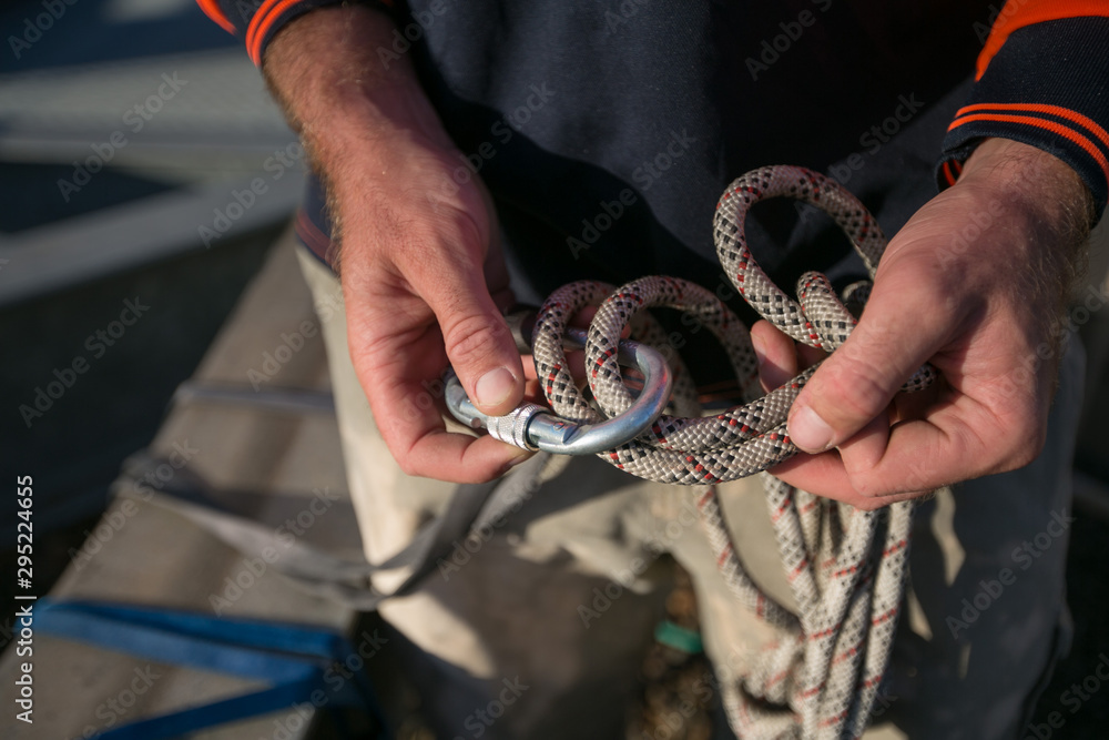 Rope access worker inspecting closing rigging on locking Karabiner its