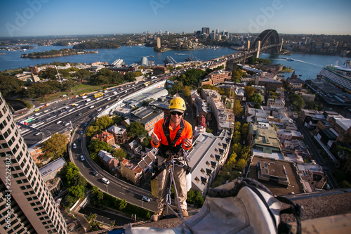 Photography Male rope access windows cleaner wearing safety hard hat, long sleeve shirt safe