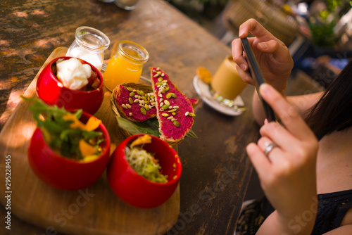 Woman hands takes photography of food on table with phone for internet blog. Smartphone photo for vegetarian, healthy and organic social networks post