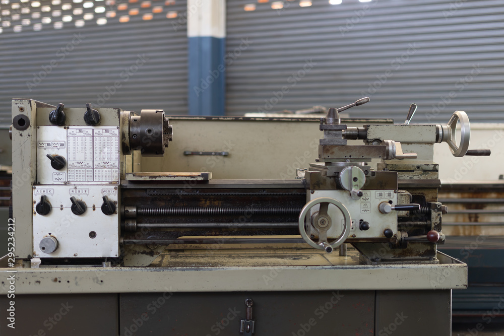 Fototapeta premium Repair of old metal lathe machine for metalworking closeup in workshop