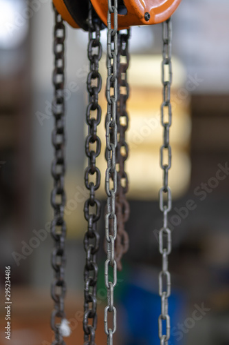 Orange steel load-lifting hook. Black steel chain. © chongsiri