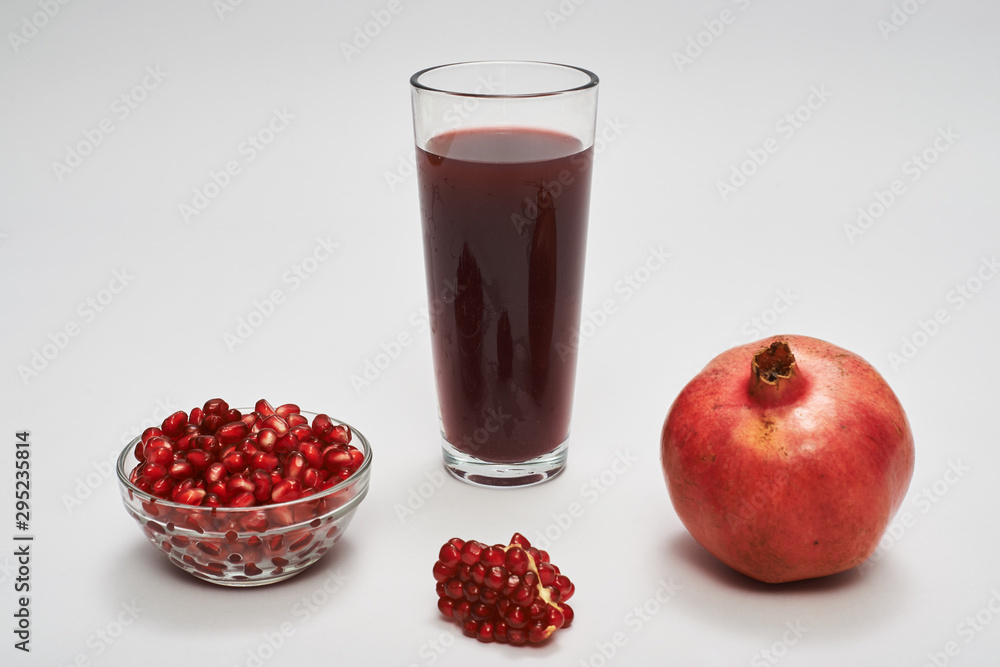 pomegranate fruits, seeds and juice on white background. pomegranate fruits, seeds and juice on white background.