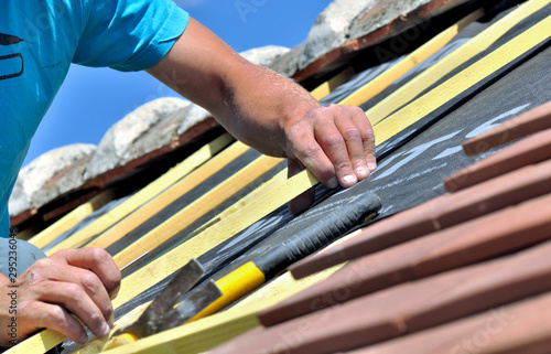 Konstfotografi close on the hands of a worker renoving e roof of a house